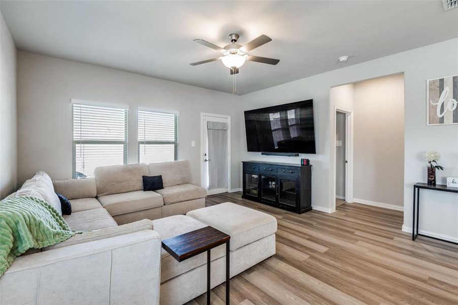 Living room with a ceiling fan and light wood-type flooring