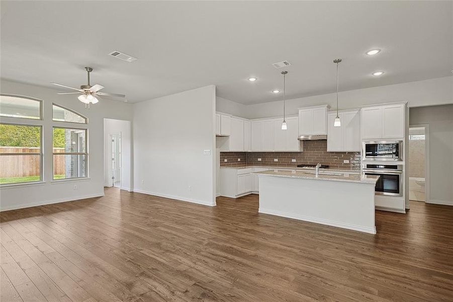 Kitchen with white cabinetry, ceiling fan, stainless steel appliances, and dark hardwood / wood-style flooring