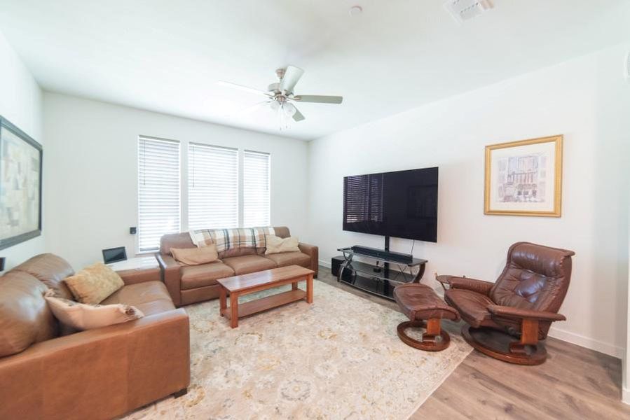 Living area featuring wood finished floors and a ceiling fan