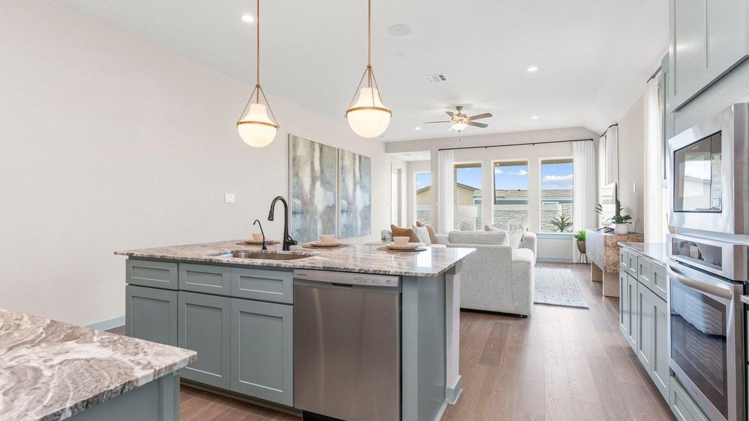 An open concept kitchen with an island with bar seating and access to the living and dining areas. An open concept kitchen with an island with bar seating and access to the living and dining areas.