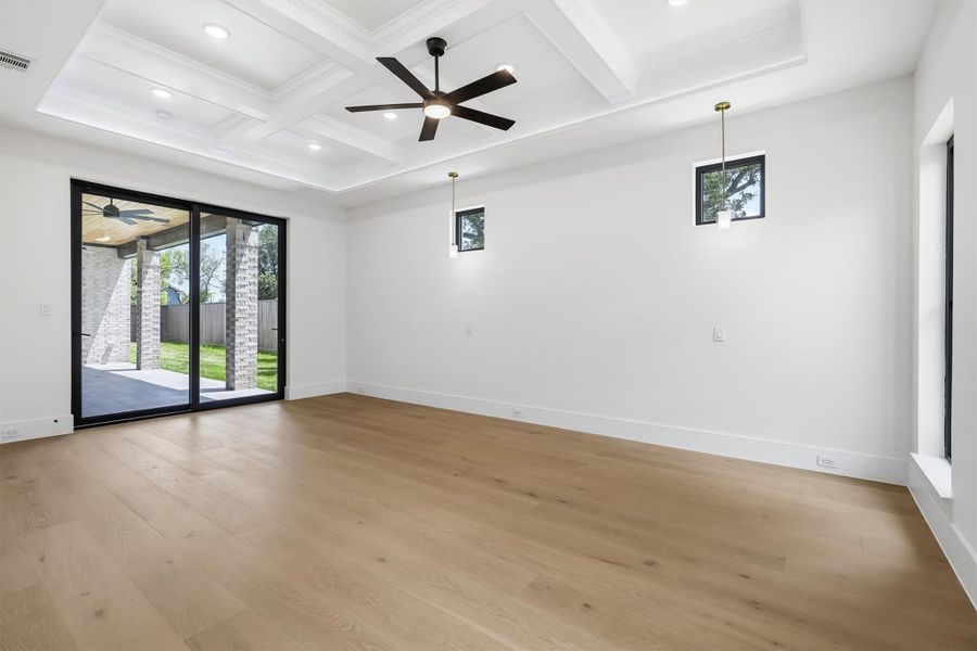The primary suite features custom lighting and paneled ceilings along with a sliding door leading to your oversized covered patio.