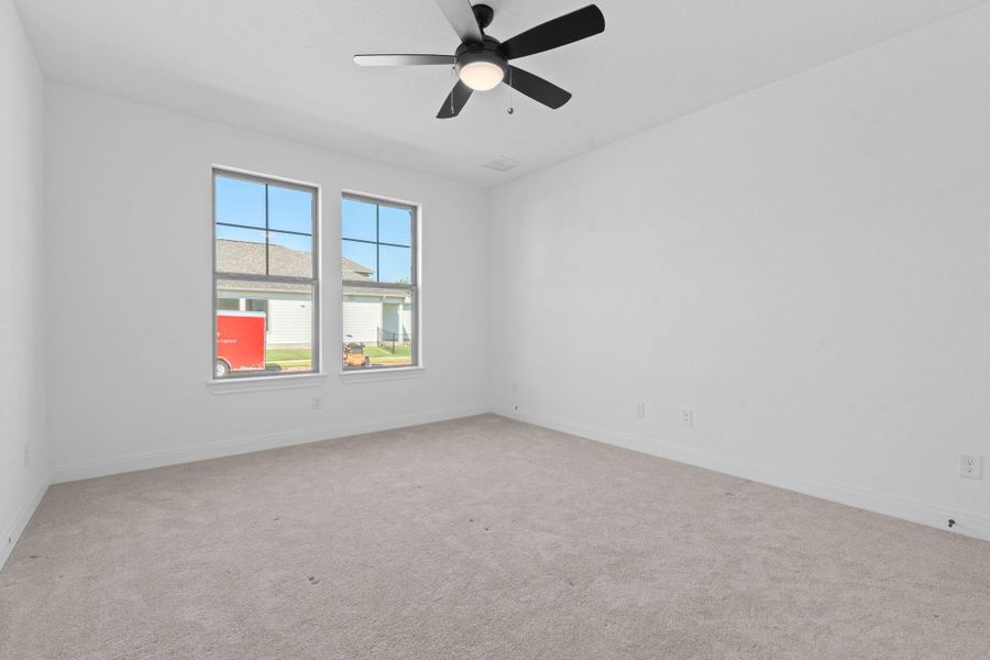 Unfurnished room with light carpet and a ceiling fan Unfurnished room with light carpet and a ceiling fan