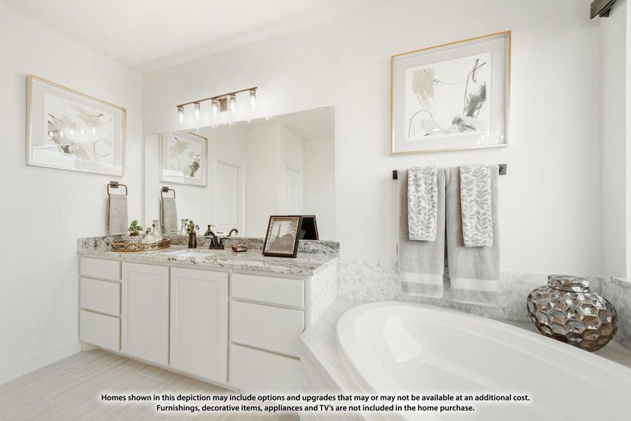 Bathroom with white double vanity, granite countertop, large mirror, and soaking tub with tile surround