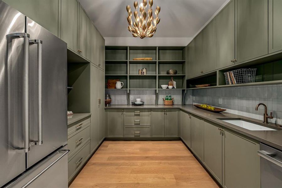Kitchen featuring stainless steel appliances, light wood finished floors, a chandelier, decorative backsplash, and open shelves
