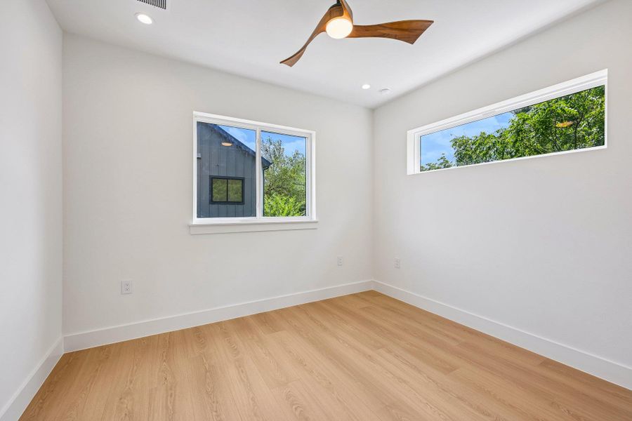Blonde wood look flooring and multiple windows enhance this bright, airy room. Blonde wood look flooring and multiple windows enhance this bright, airy room.