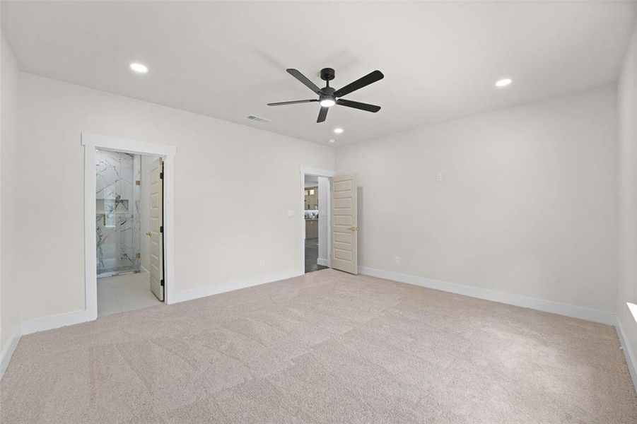 Spacious interior featuring neutral carpeting, a modern black ceiling fan, and recessed lighting Spacious interior featuring neutral carpeting, a modern black ceiling fan, and recessed lighting