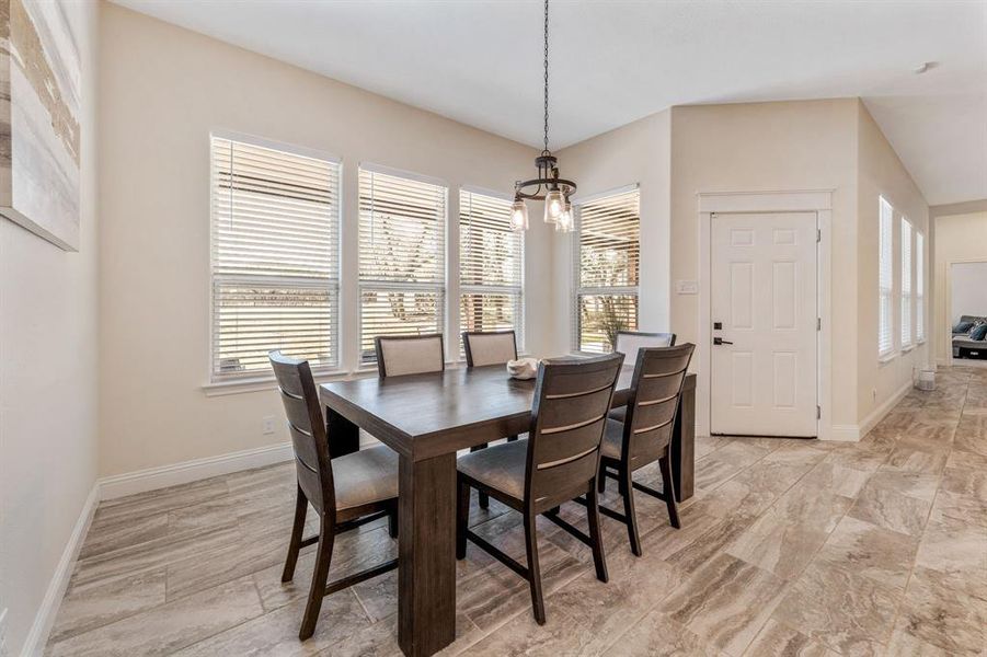 Dining room featuring healthy amount of natural light and a chandelier Dining room featuring healthy amount of natural light and a chandelier