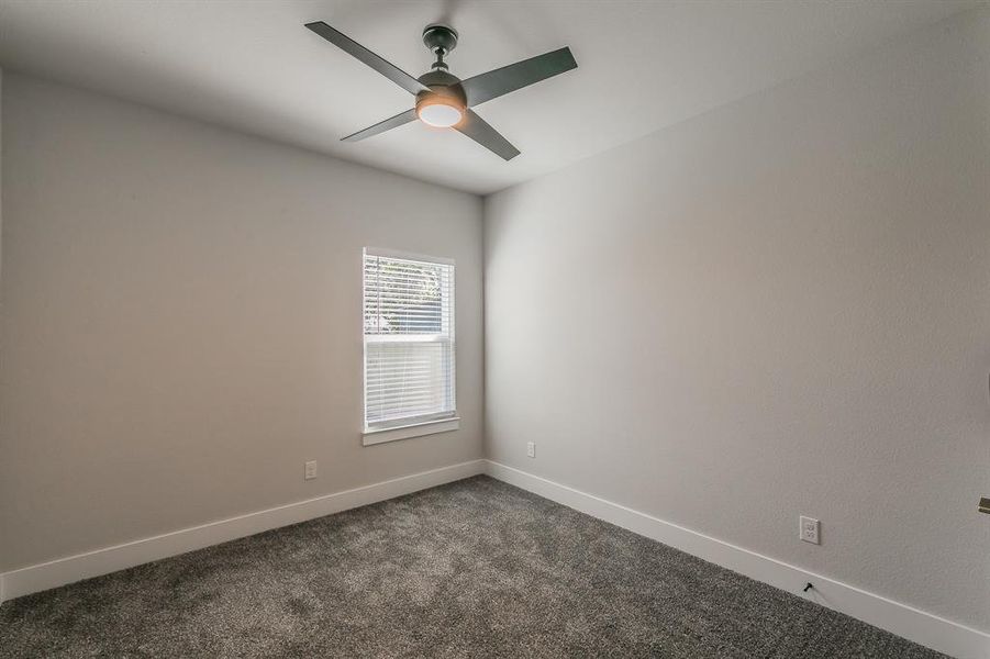 Carpeted spare room featuring ceiling fan