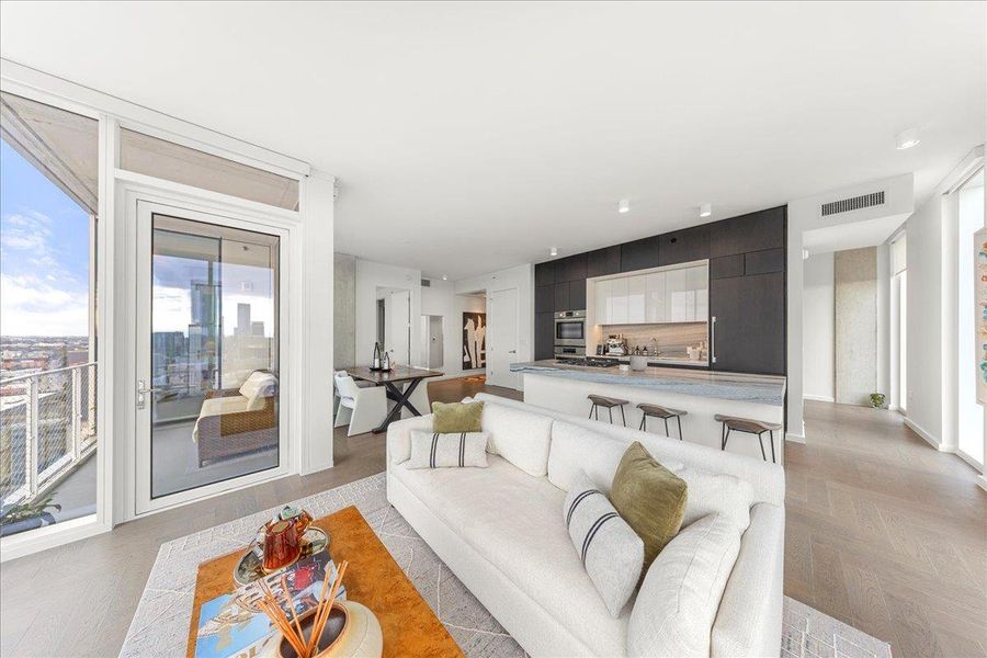 Open living, dining and kitchen spaces lined with floor-to-ceiling glass, with direct access to the private terrace and a separate den tucked just beyond the kitchen ideal for an office, library or flex room.