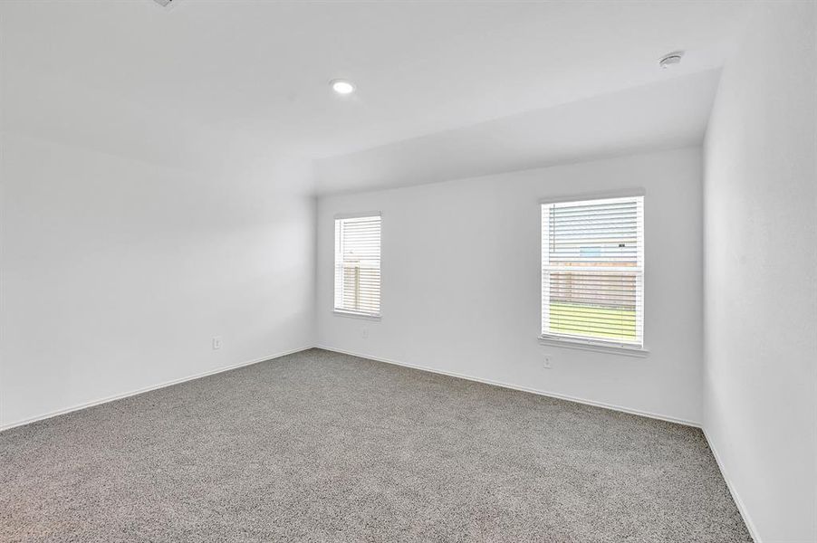 The primary bedroom is positioned adjacent to the backyard, offering enhanced privacy and a quieter setting. The window above the bedside table provides convenient natural light, ideal for reading.