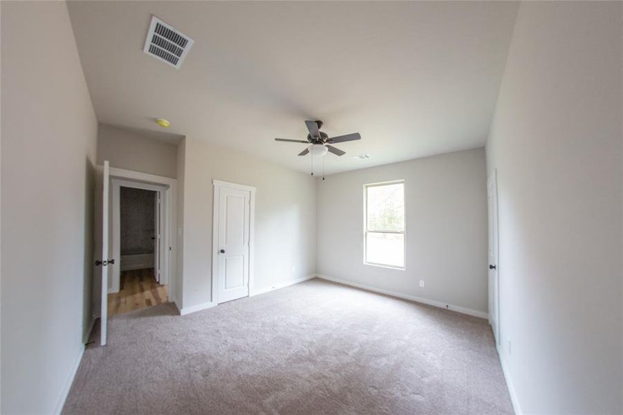 Unfurnished bedroom featuring light colored carpet and ceiling fan