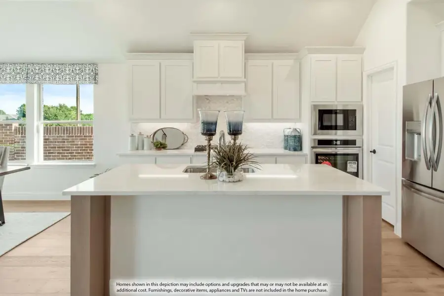 Kitchen with white cabinets, large center island, quartz countertops, and stainless steel appliances