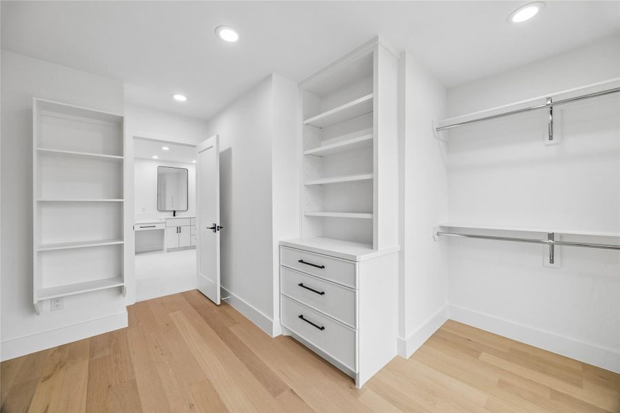 Designed with a boutique-inspired layout, the primary closet offers open display shelving, dedicated wardrobe storage, and flexible space for seasonal organization. The scale of the room allows the area to function more like a private dressing suite than a traditional closet.