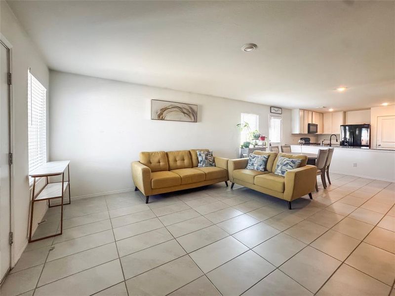 Living area with light tile patterned floors and recessed lighting
