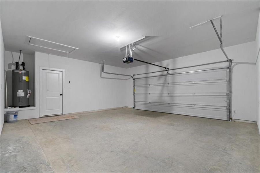 Garage featuring water heater and a garage door opener