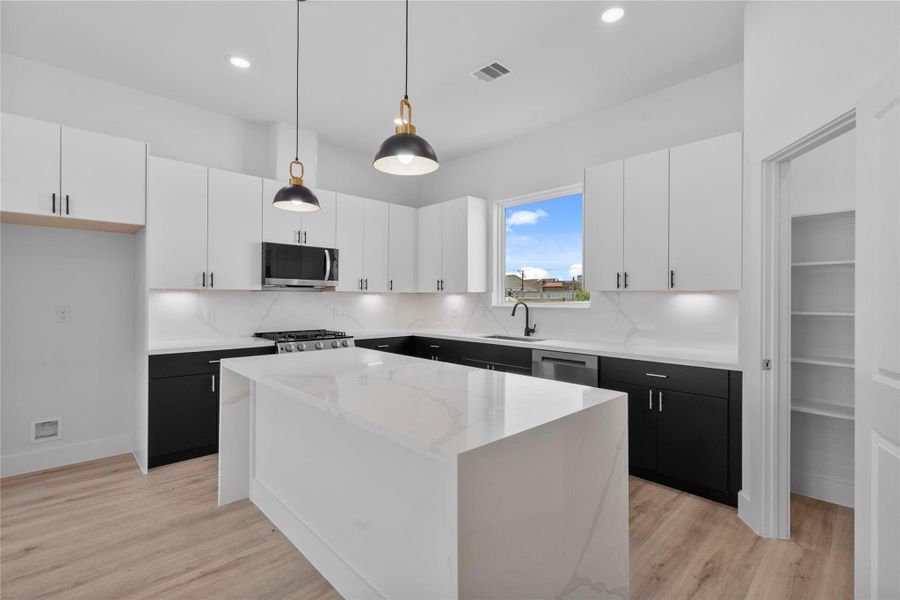 Sophisticated chef’s kitchen featuring dramatic two-tone cabinetry, quartz counters and premium modern finishes Sophisticated chef’s kitchen featuring dramatic two-tone cabinetry, quartz counters and premium modern finishes