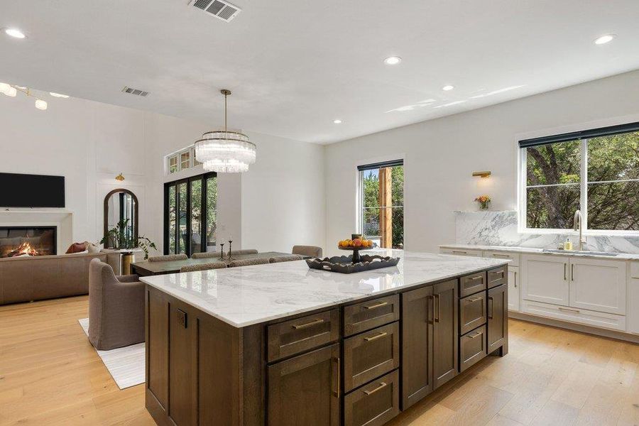 An open concept living area showcasing a grand kitchen island with a gleaming countertop. An open concept living area showcasing a grand kitchen island with a gleaming countertop.