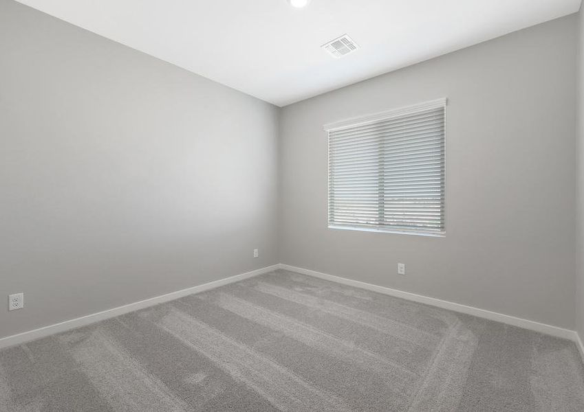 Secondary bedroom with tan carpet and recessed lighting.