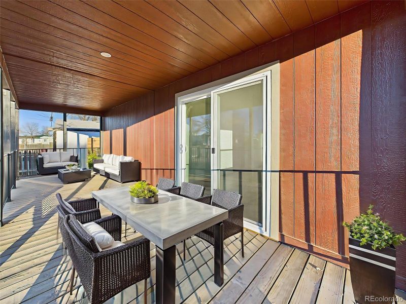 Virtually Staged This expansive covered porch offers ample room for dining and lounging, perfect for enjoying outdoor living year-round.