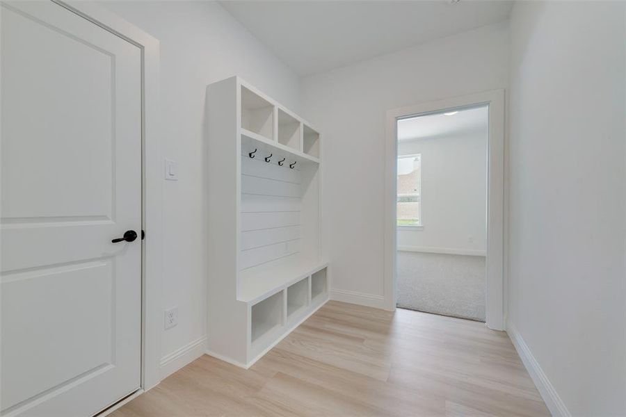 Mudroom featuring light carpet