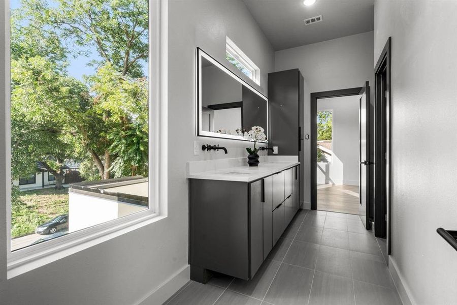 Bathroom featuring double vanity and dark tile patterned flooring