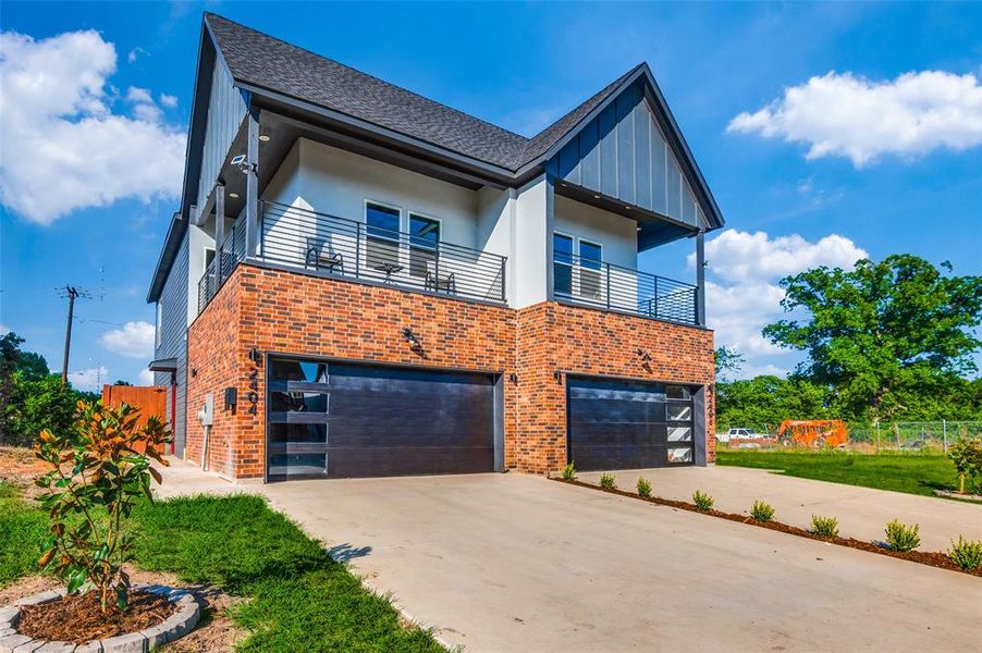 View of front of property with a garage and a balcony