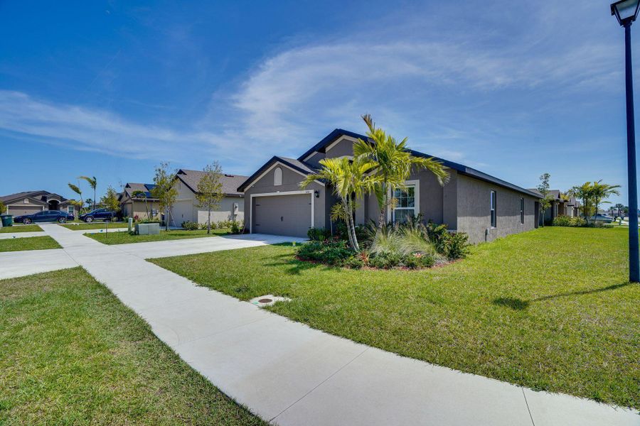 Front exterior of a new home in Celebration Pointe, Fort Pierce, FL, highlighting curb appeal (Image 18).