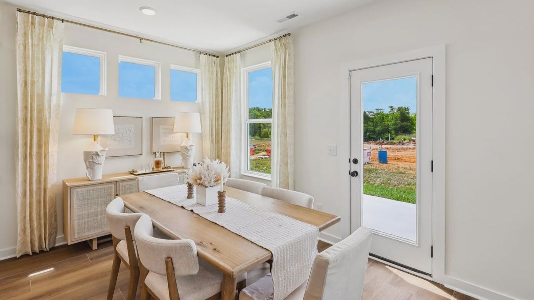 Dining area with natural lighting from windows and access to rear entrance