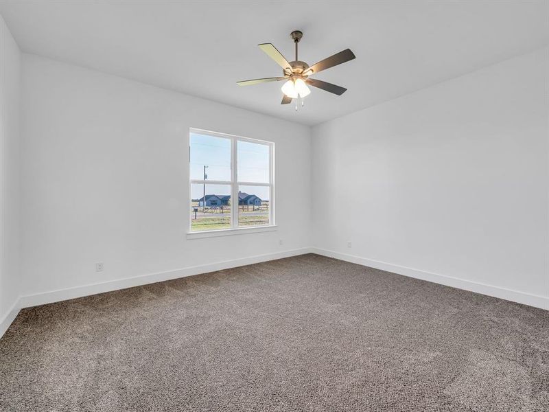 Carpeted spare room with ceiling fan