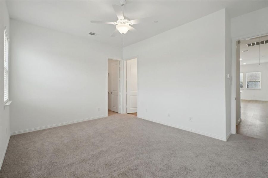 Carpeted empty room with ceiling fan