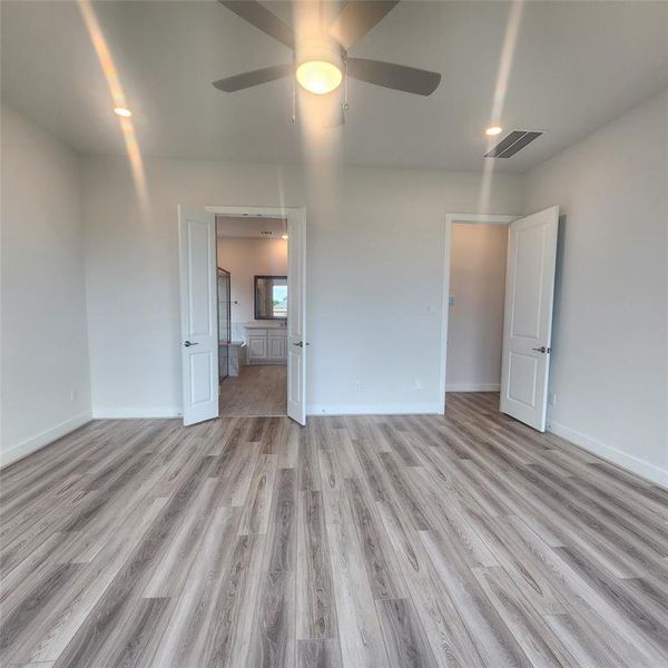 master suite with ceiling fan