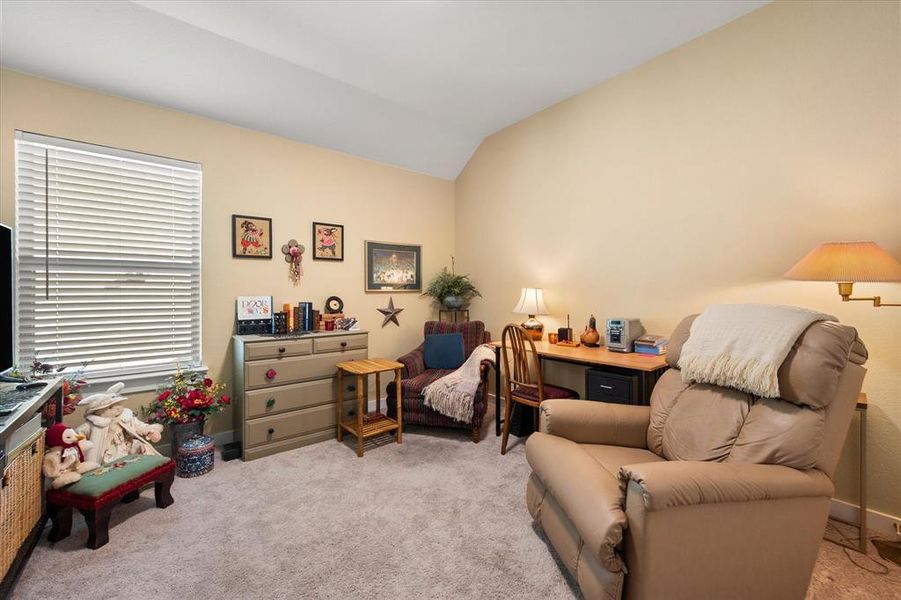 Living area featuring light colored carpet and lofted ceiling Living area featuring light colored carpet and lofted ceiling