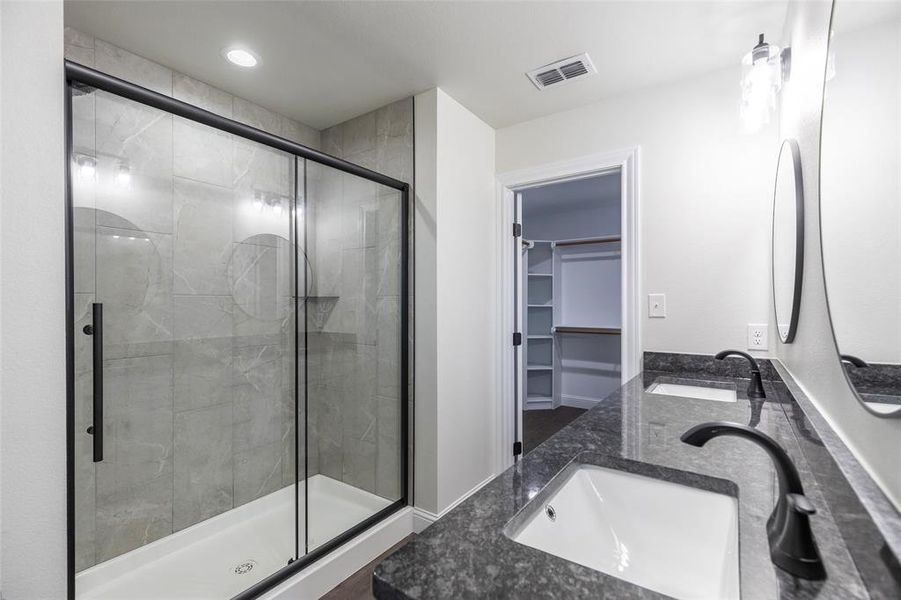 Modern bathroom featuring a glass-enclosed shower with black framing, gray subway tile, and a built-in shower niche