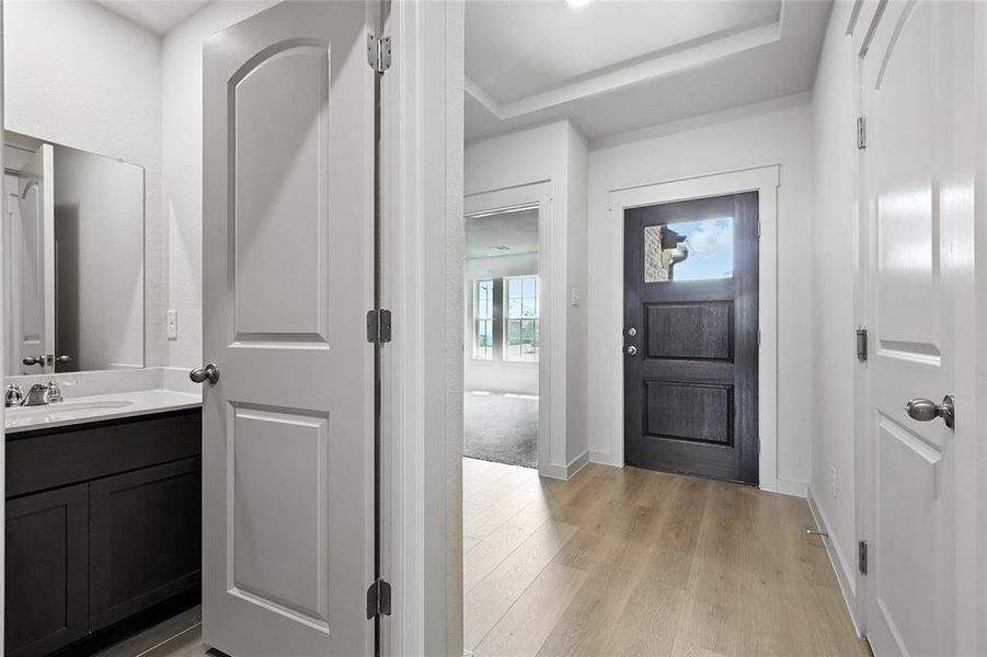 Entrance foyer with light wood-style floors and a raised ceiling Entrance foyer with light wood-style floors and a raised ceiling