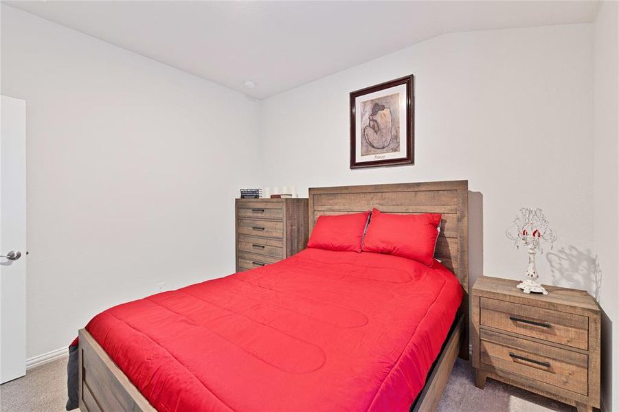 Carpeted bedroom featuring lofted ceiling