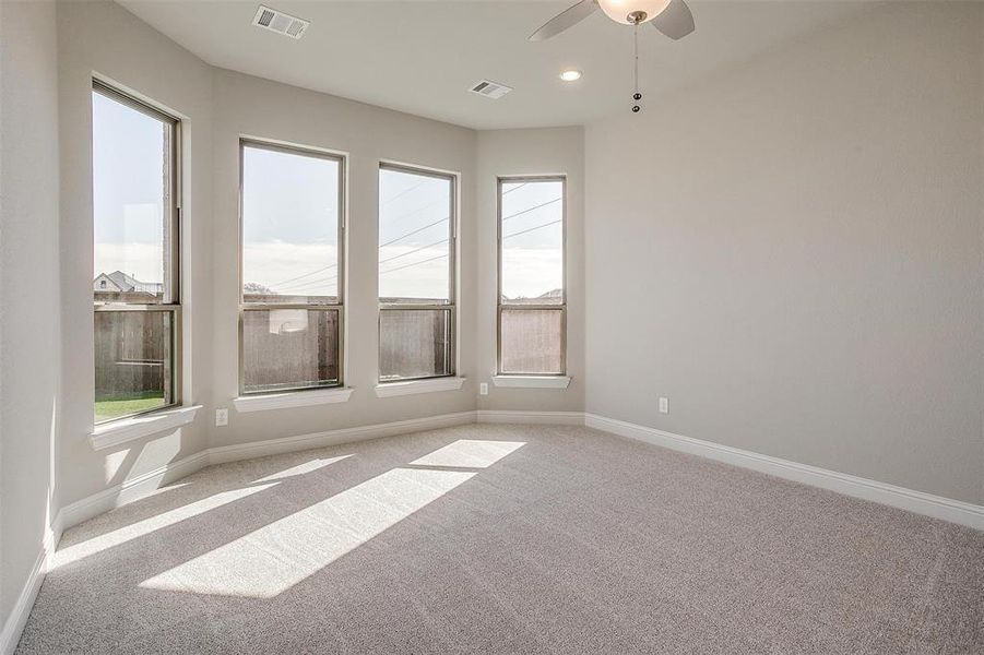 Carpeted empty room with ceiling fan