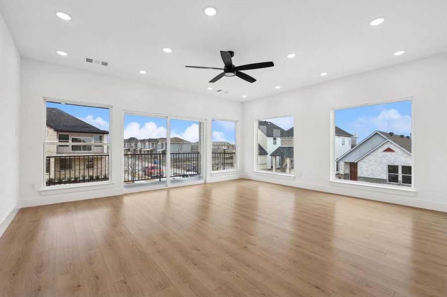 Unfurnished living room featuring ceiling fan and light wood-type flooring