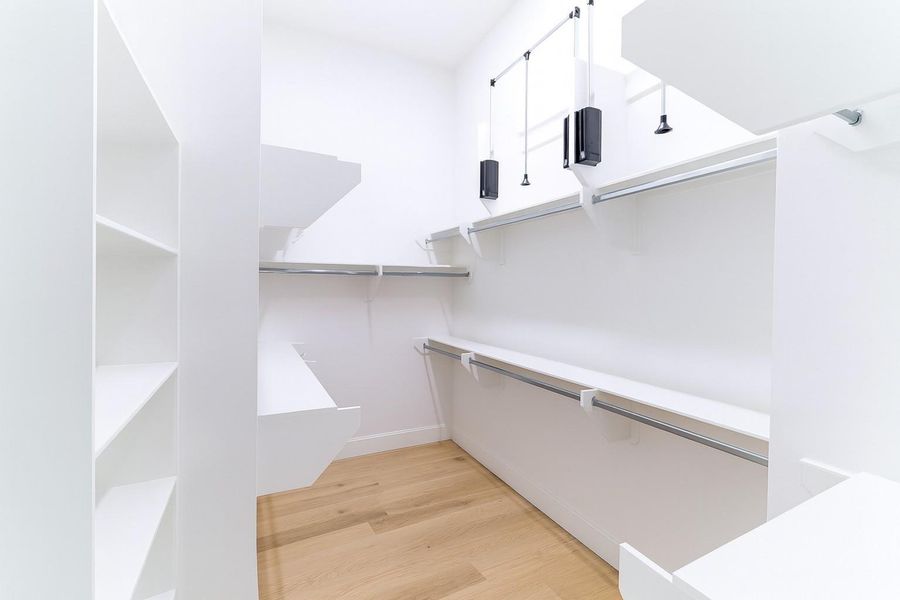 Huge closet in primary bedroom with pull-down racks for extra storage of seasonal clothing and shelving too.