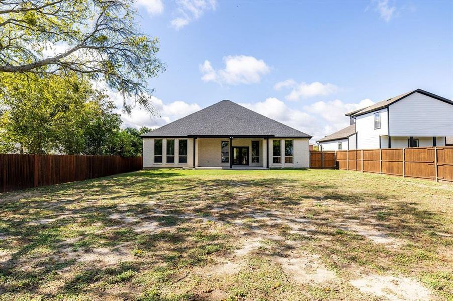 Back of property featuring a patio area, roof with shingles, a fenced backyard, and brick siding