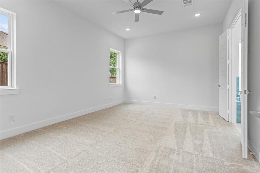 Carpeted spare room featuring ceiling fan