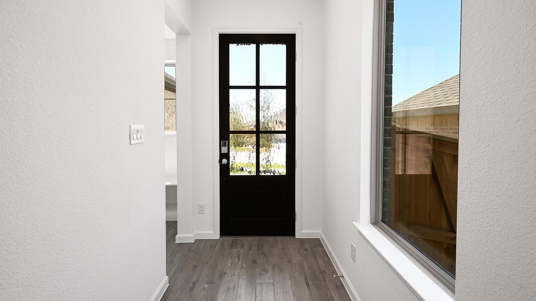 Entryway with wood finished floors and a textured wall Entryway with wood finished floors and a textured wall