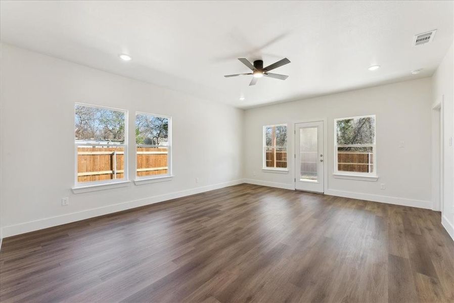 Unfurnished living room featuring wood-style vinyl floors and ceiling fan