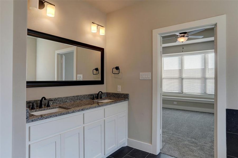 Bathroom featuring ceiling fan, vanity, and tile patterned flooring