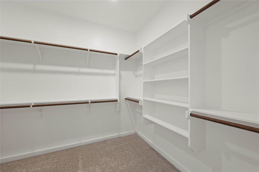 Ample built-in shelving and hanging rods create an organized and versatile wardrobe space.