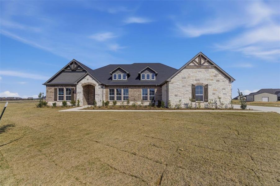 View of front of house with a front lawn, stone siding, and brick siding View of front of house with a front lawn, stone siding, and brick siding