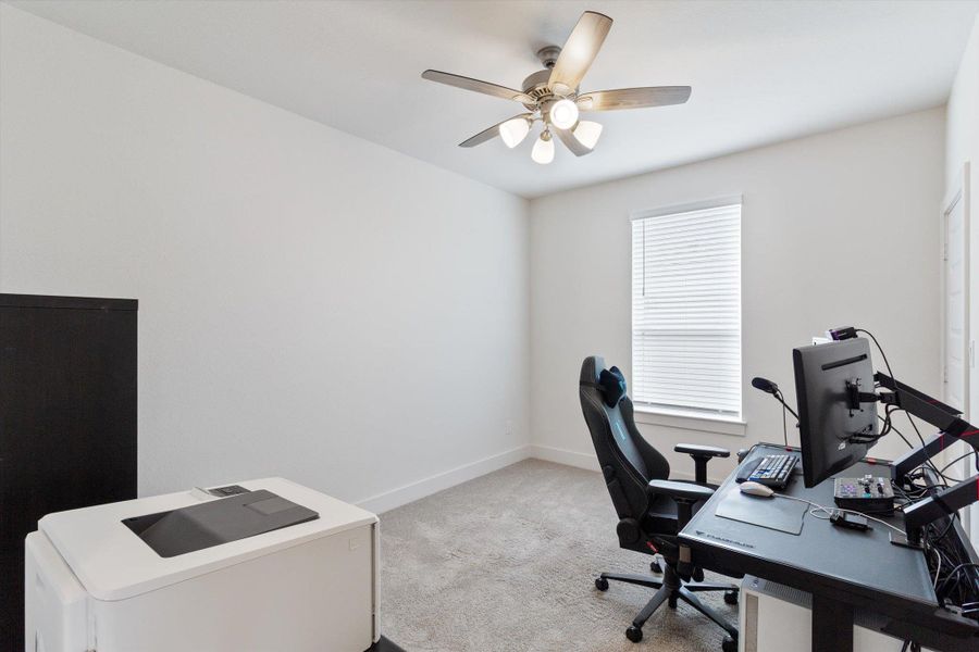 Home office featuring light carpet and ceiling fan