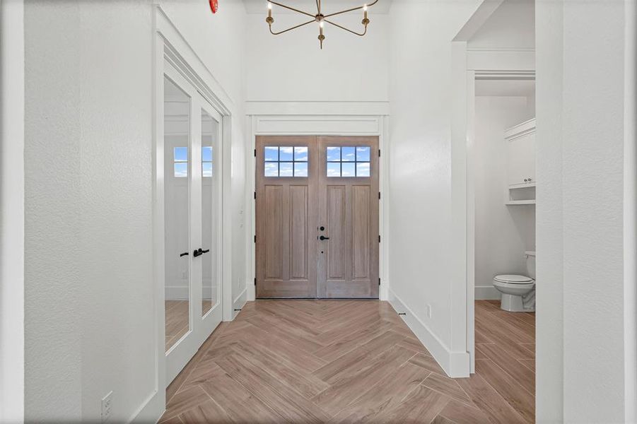 Entrance foyer featuring a chandelier and parquet floors Entrance foyer featuring a chandelier and parquet floors