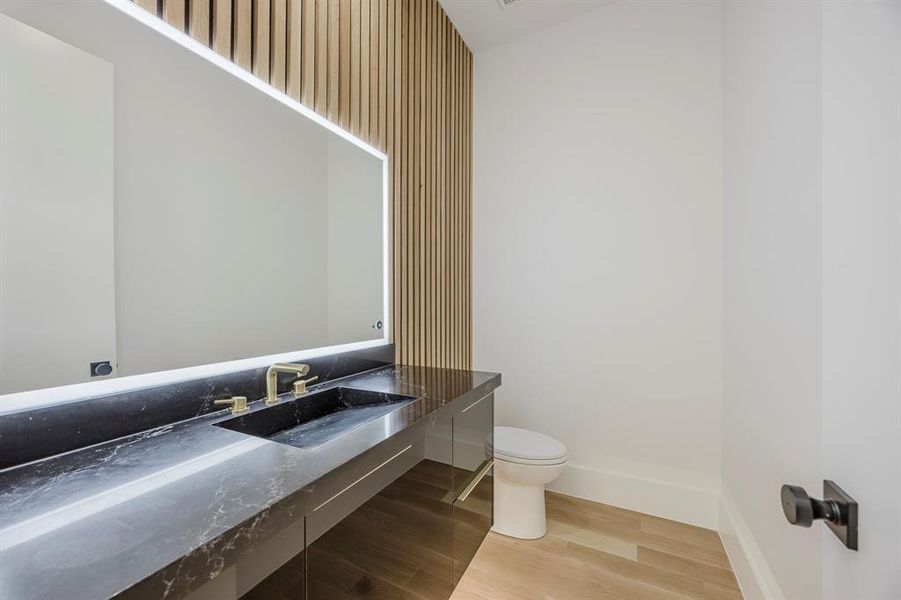 Half bathroom featuring vanity and light wood-style floors Half bathroom featuring vanity and light wood-style floors
