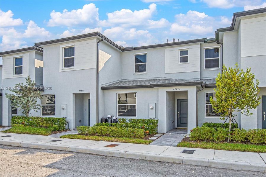 Front exterior of a new home in , Homestead, FL, highlighting curb appeal (Image 1). Front exterior of a new home in , Homestead, FL, highlighting curb appeal (Image 1).
