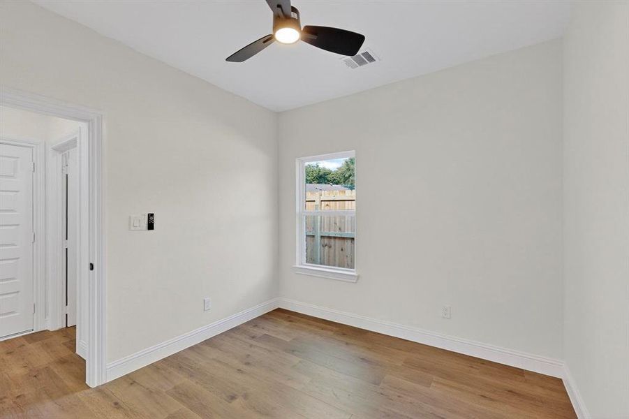 Spare room featuring light wood finished floors and a ceiling fan Spare room featuring light wood finished floors and a ceiling fan